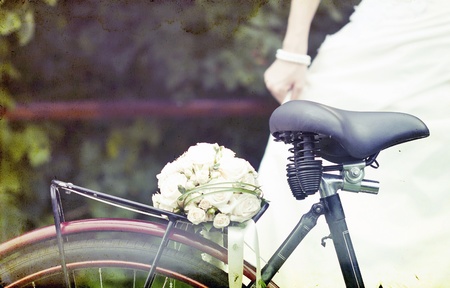 Vintage photo of bride and wedding bouquet on a bicycle の写真素材