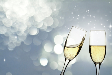 Glasses with champagne against holiday light and snowflakesの写真素材