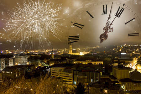 Holiday fireworks and clock close to midnight over the city