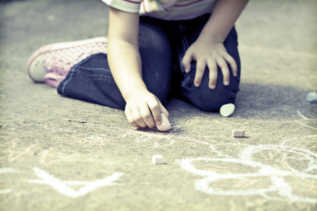 Back to school concept -Photo of girl writing with chalk on the schoolyard の写真素材