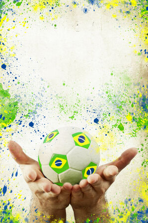 Vintage photo of hands holding soccer ball of Brazil 2014 and flagの写真素材