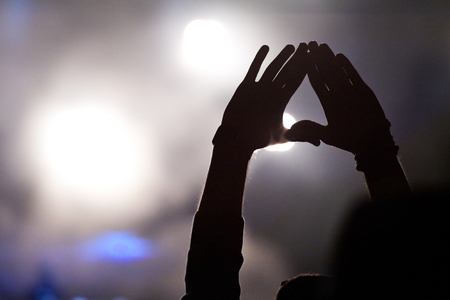 Cheering crowd in front of bright colorful stage lights