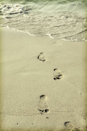 Footsteps in the sand on the beachの写真素材