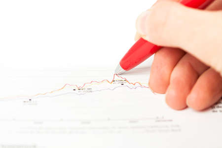 Close-up of female hand holding pen over business graphの写真素材