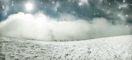 Winter landscape with snow covered hill and cloudy blue sky