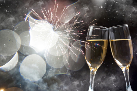 Glasses with champagne against nigth sky with fireworksの写真素材