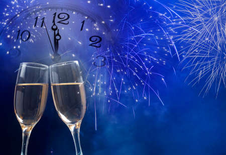 Glasses with champagne against holiday lights and clock close to midnightの写真素材