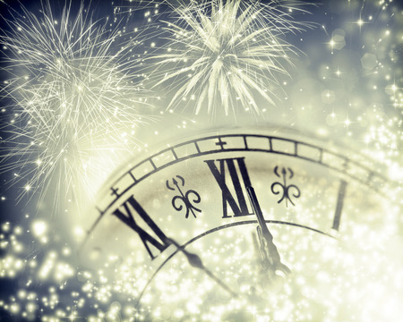 New Year's at midnight - Old clock with fireworks and holiday lights