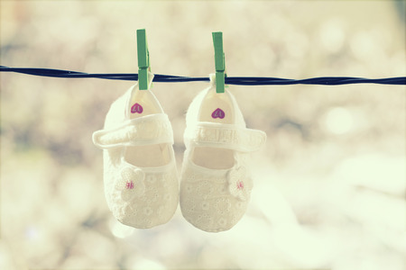 Baby shoes  hanging on the clotheslineの写真素材