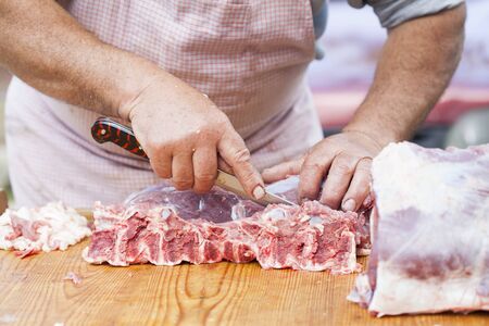 Butcher chopping meat outdoorsの写真素材