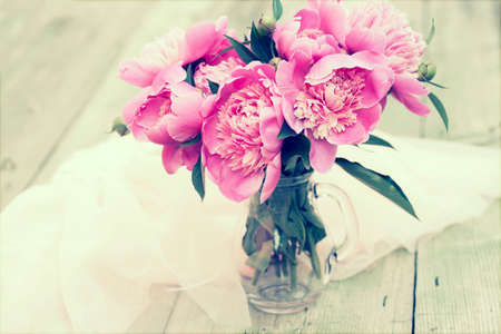Pink peonies on wooden floor - vintage photoの写真素材