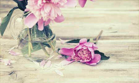 Pink peonies on wooden floor - vintage photoの写真素材