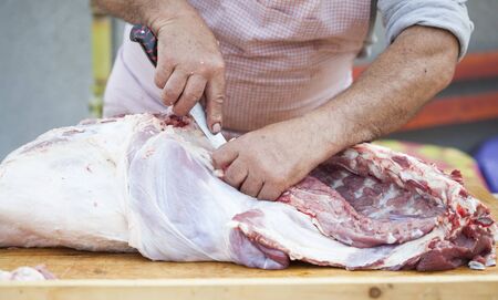 Butcher chopping meat outdoorsの写真素材