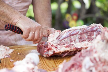 Butcher chopping meat outdoorsの写真素材