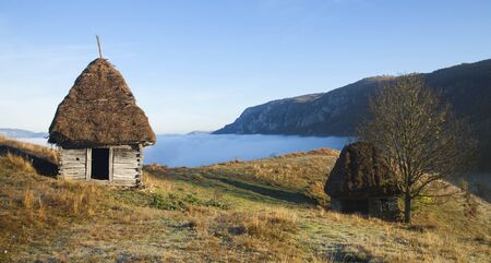 Small cottage in the mountains in the fog, Transylvania, Romania