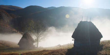 Small cottage in the Carpathian  mountains in the morning fog-panoramic view,  Transylvania, Romaniaの写真素材