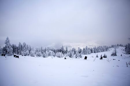 Winter landscape with snow covered hill and cloudy blue sky