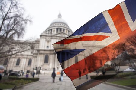 Union Jack flag and iconic London landmarks in the backgroundの写真素材
