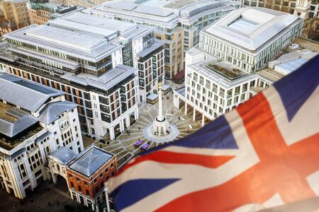 British Union Jack flag and aerial view of London with financial symbols of London in the background - Brexit conceptの写真素材