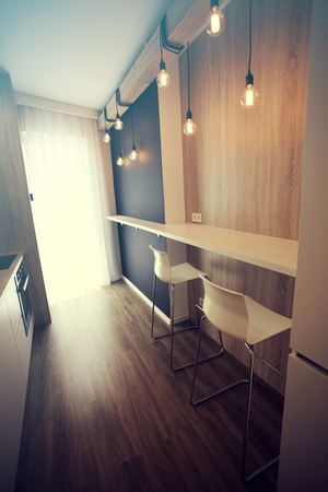 Small, white kitchen room interior with dining and cooking spaceのeditorial素材