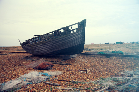 Blue fishing nets and lengths of rope and old boat at Dungeness pebble beach, Kent, Englandの写真素材