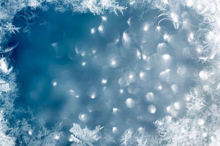 Magic blue holiday abstract glitter background with blinking stars and falling snowflakes. Blurred bokeh of Christmas lights.の写真素材