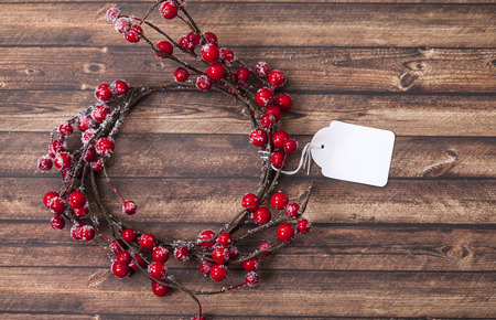 Red berry holiday wreath on old wooden table