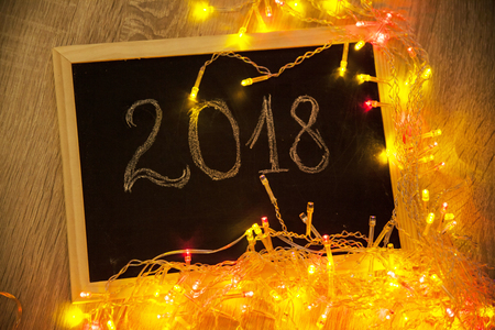 Colorful glowing Christmas lights and 2018 text on small blackboard - New Year conceptの写真素材