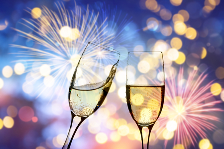Glasses with champagne against fireworks and holiday lights - Celebrating the New Yearの写真素材