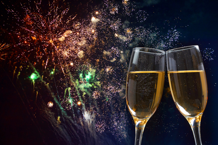 Glasses with champagne against fireworks and holiday lights - Celebrating the New Yearの写真素材