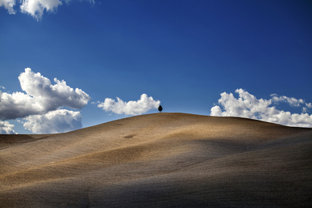 Beautiful view of the blue sky and rolling hills of the Tuscan countryside in autumn in Italyの写真素材