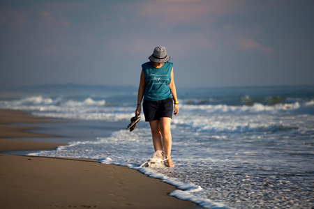 Young woman walking along the beachの写真素材