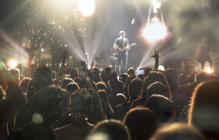 Crowd at concert - Cheering crowd in bright colorful stage lightsの写真素材