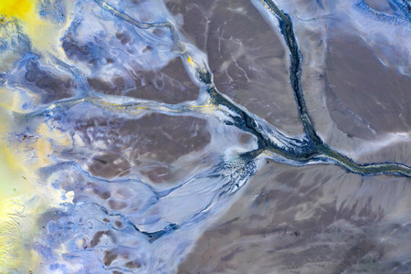 Beautiful aerial pattern of colorful water and mud, shot with a drone located at Geamana, Romania, a...