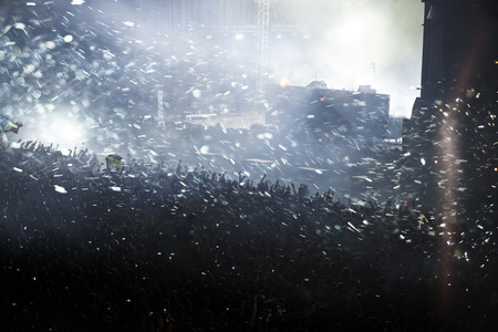 Crowd at concert - Cheering crowd in front of bright colorful stage lightsの写真素材