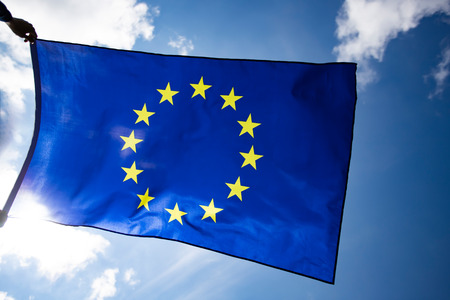Waving European Union flag on blue sky.