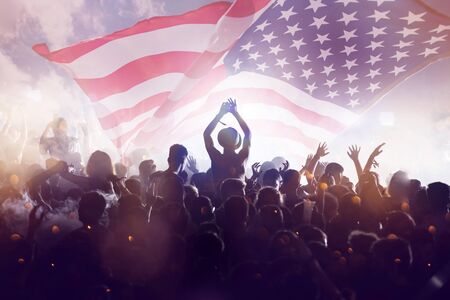 Crowd of people celebrating Independence Day. United States of America USA flag with fireworks...