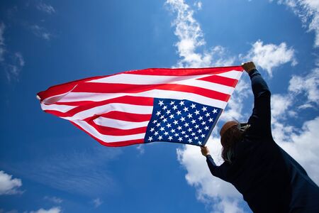 Young woman holding american USA flag. Independence Day or traveling in America concept.の写真素材