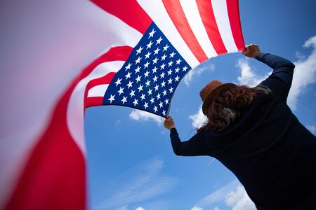Young woman holding american USA flag. Independence Day or traveling in America concept.