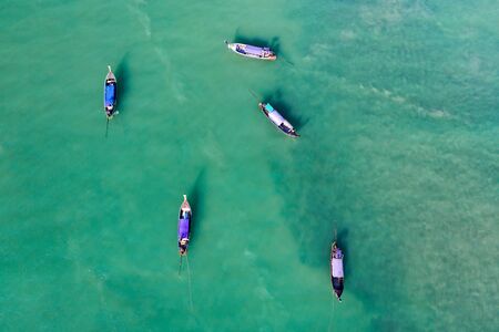 Aerial, drone view of turquoise clear water and longtail boats near Krabi, Thailand