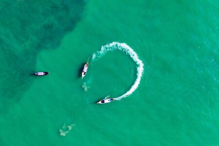 Aerial, drone view of turquoise clear water and longtail boats near Krabi, Thailandの写真素材
