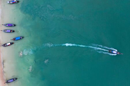 Aerial, drone view of a beautiful tropical beach with white sand, turquoise clear water and longtail boats near Krabi, Thailand.の写真素材