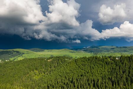 Drone view of dark sky and dramatic black cloud before rain. Storm over the village and mountains.