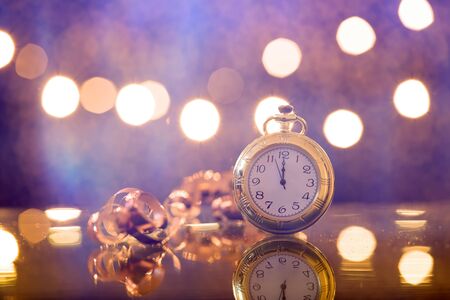 Old golden clock close to midnight and sparkling Christmas decoration - New Year concept