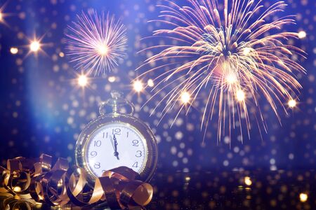 New Year's at midnight - Old clock with fireworks and holiday lightsの写真素材
