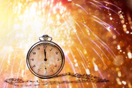 New Year's at midnight - Old clock with fireworks and holiday lightsの写真素材
