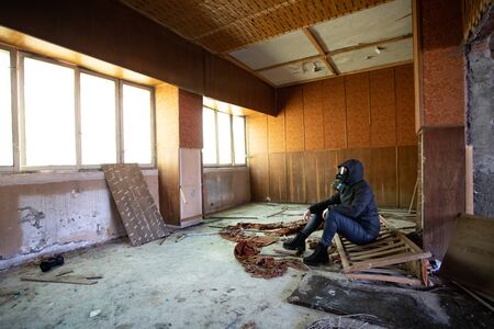 Post apocalyptic survivor in gas mask in a ruined building. Environmental disaster, armageddon...