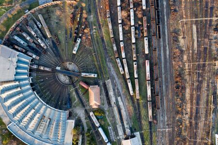 Aerial view of various railway carriage trains with goods on the railway station, top view.