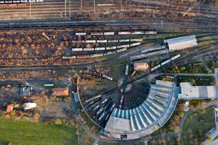 Aerial view of various railway carriage trains with goods on the railway station, top view.