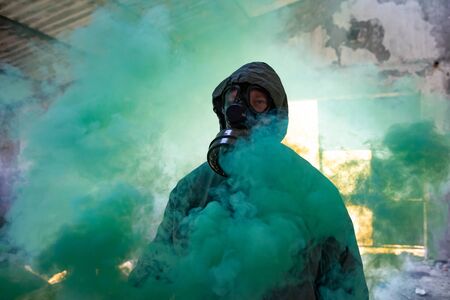 Post apocalyptic survivor in gas mask in the smoke. Environmental disaster, armageddon concept.の写真素材